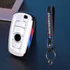 Juego de funda para llave de coche de fibra de carbono negra y azul con anillo metálico, junto a un dispositivo electrónico p