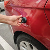 يد تسحب أداة سحب للثنيات السوداء من المصد الخلفي لسيارة حمراء.