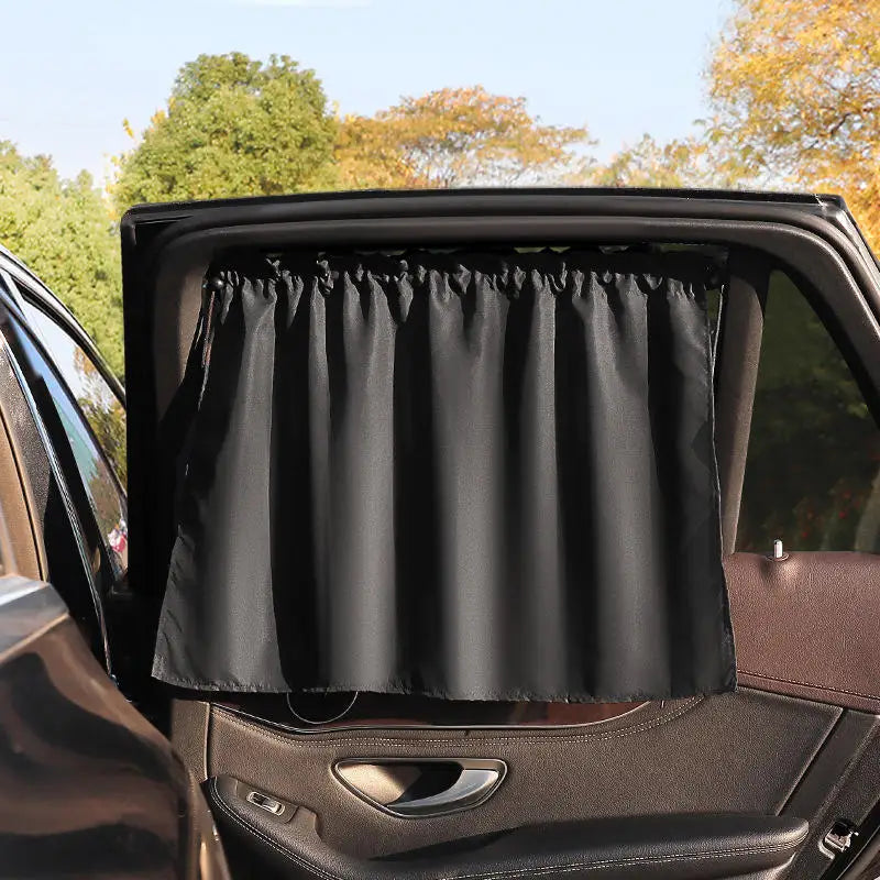 A black suction cup window sunshade is shown inside a car window.