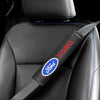 A black car seat with a red and blue Ford branded carbon fiber shoulder belt pad cover.