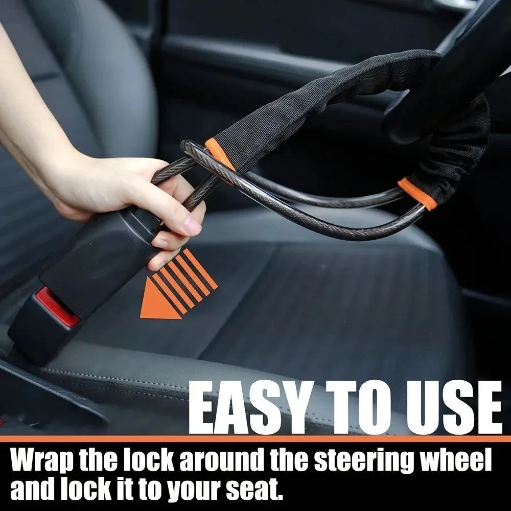 A hand is wrapping a black and orange anti-theft lock around a car steering wheel for security.