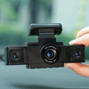 Une main tient une caméra de voiture dashcam noire avec objectif grand angle et surveillance de vue arrière.