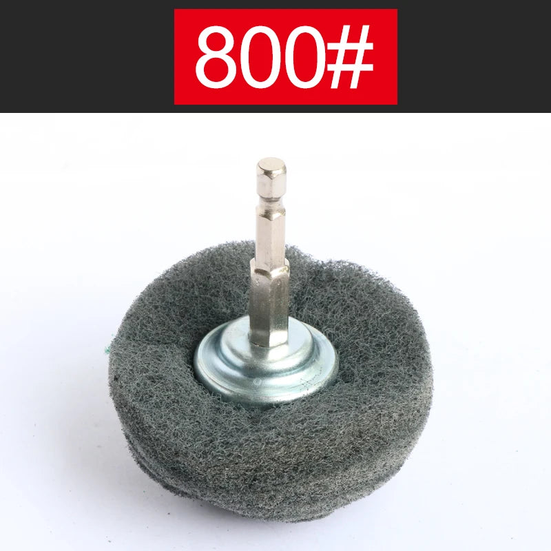 A precision flap sanding wheel with a metal shaft mounted on a gray abrasive pad.