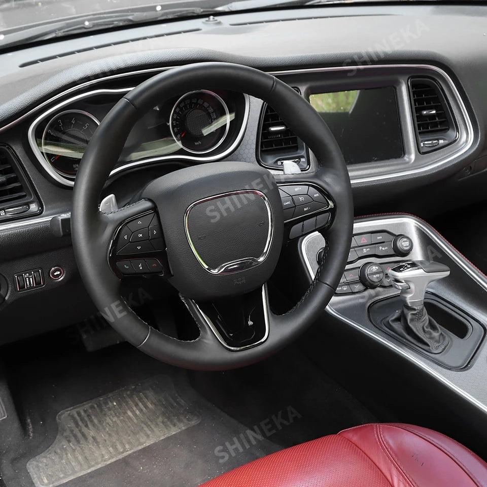 Interior view of a car steering wheel with a decorative cover and controls visible.