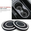 A set of two black and white silicone car cup holder coasters shown next to a product interior.