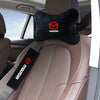 A black headrest seat belt shoulder pad with a Mazda logo is placed on a light brown car seat.
