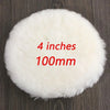 A round, white, fluffy polishing disc measuring 4 inches or 100mm resting on a dark wooden surface.