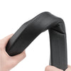 A hand holds a black universal car seat gap filler strip, showing its shape and texture.