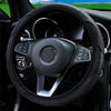 A black PU carbon fiber steering wheel cover with red stitching inside a car interior.