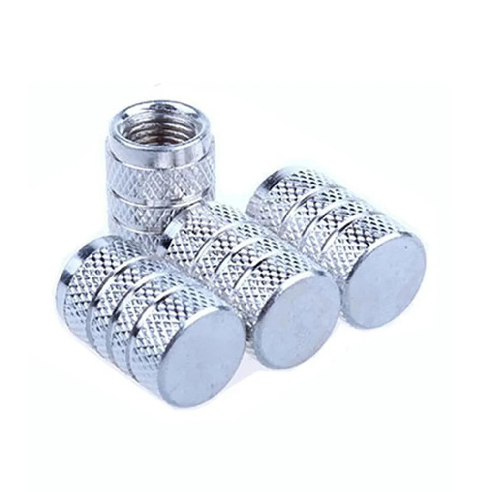 A set of silver aluminum tire valve caps, including a threaded cap and several smooth dome-shaped caps.
