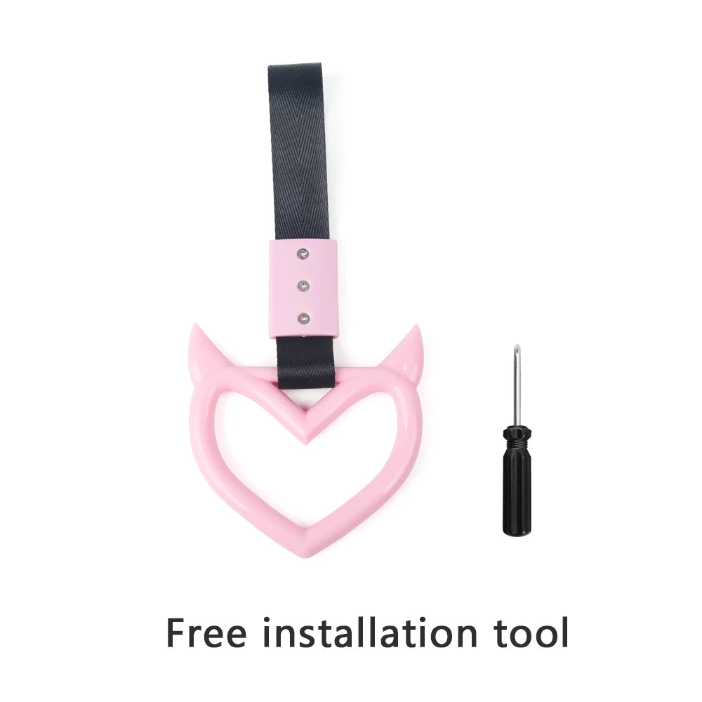 A pink strap and black hand pull ring used as a free installation tool for a car rear bumper warning.