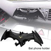Black bat phone holder mount installed in a car dashboard slot.