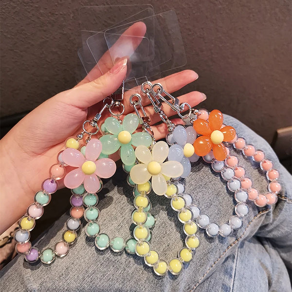 A hand holds a phone anti-loss lanyard featuring round bead pendants in pastel colors like pink, yellow, and orange.