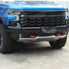 Close-up of a blue Ford F-150 truck exterior with a black grille and an aftermarket bumper tow hook cover.