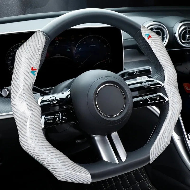 A close-up view of a black steering wheel with a white carbon fiber cover and controls inside a car interior.