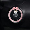 A decorative rhinestone bow bell trim for a car start engine stop button.