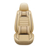 Tan leather car seat covers for a five-seater vehicle, featuring stitching and decorative pillows.