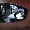 Close-up view of a black car blind spot mirror with a clear lens reflecting the exterior.