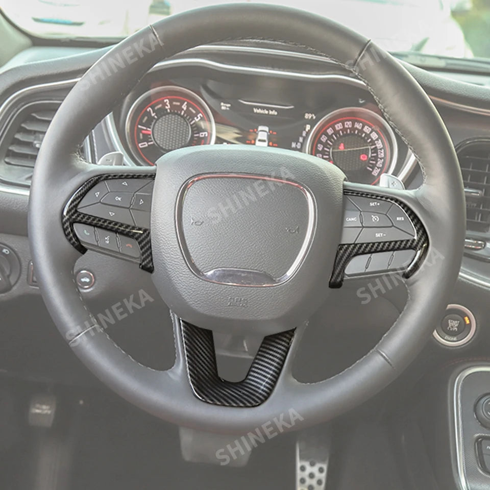A close-up view of a steering wheel with a black leather cover and carbon fiber accents inside a car