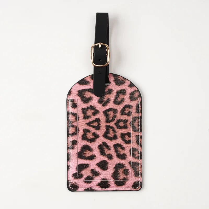 A black leather passport holder with a leopard print design and a black strap.