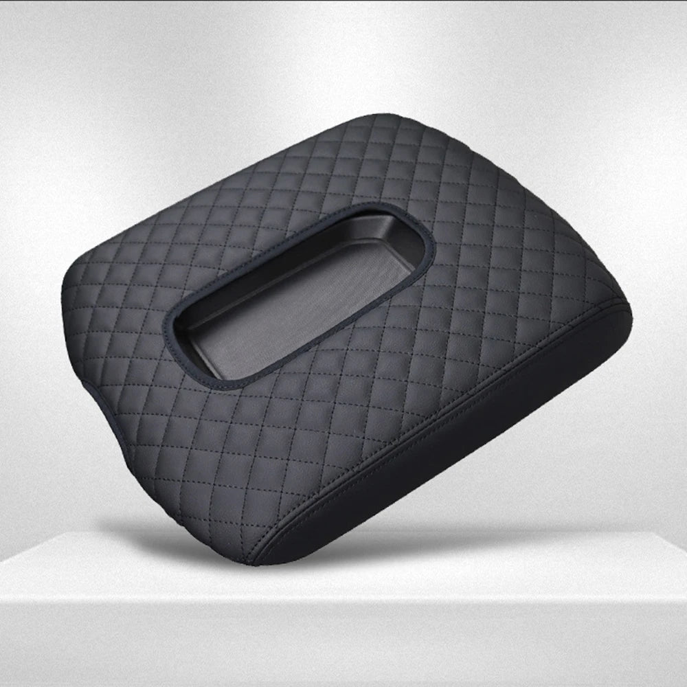 A dark gray quilted microfiber armrest pad for a vehicle interior.