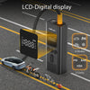 A black portable LCD digital display tire inflator is shown with various modes and units, placed on an asphalt road with a ca