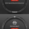 A close-up view of a black steering wheel cover, demonstrating two options: carbon-grain suede and high quality Nappa pi leat