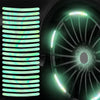 Gros plan sur une roue de voiture ou de moto avec des autocollants verts brillants et un motif à fentes verticales.
