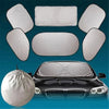 A set of six white car windshield sun shades displayed above a black car.