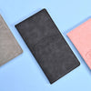 Schwarzer Leder-Dokumentenhalter mit Autosilhouette neben einem pinken auf einer hellblauen Oberfläche.