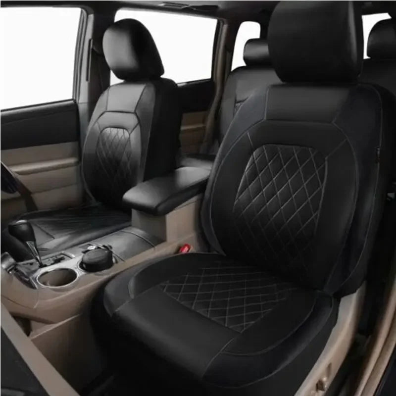 Interior view of a car seat with black leather covers installed on the seats and dashboard.