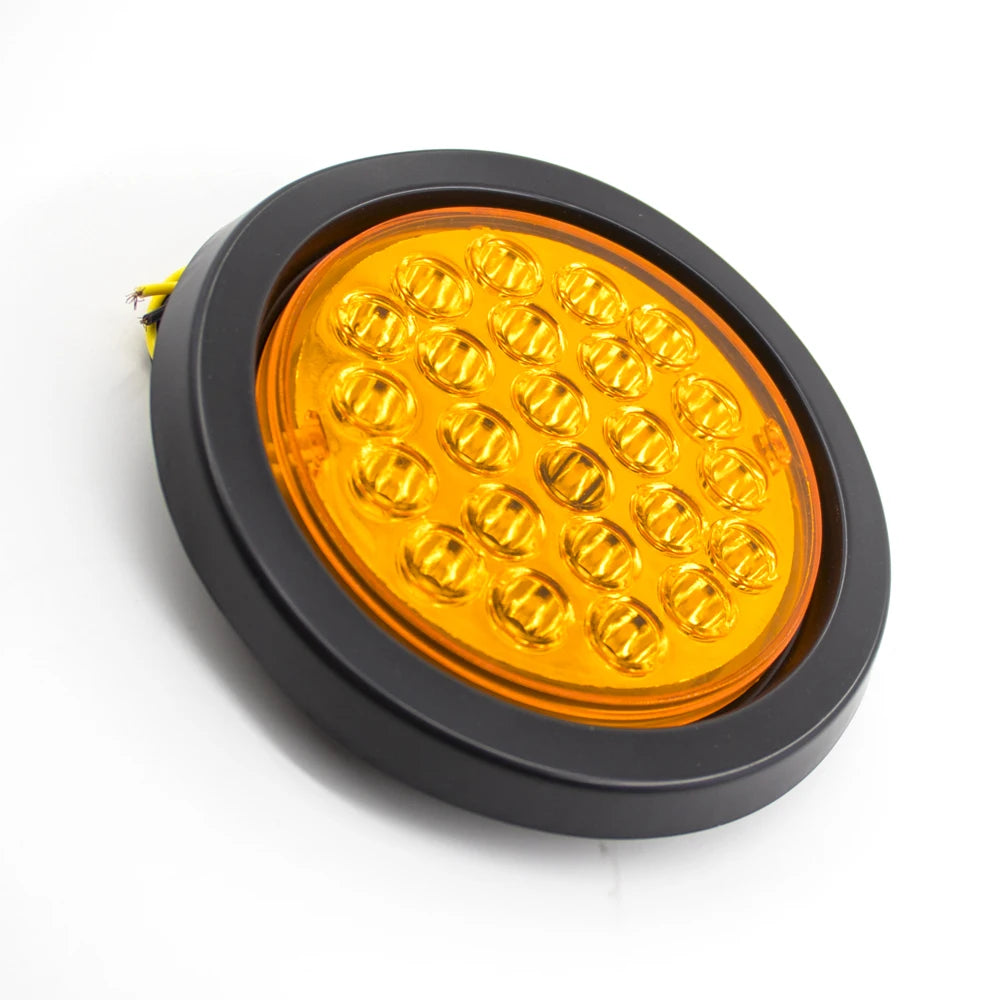 An orange round LED trailer tail light with brake and turn signal inside a black housing.
