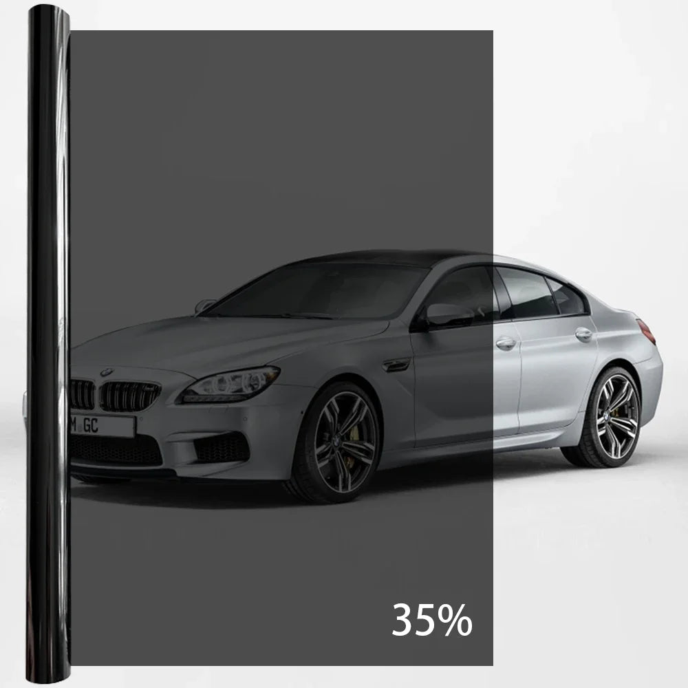 A silver BMW sedan with a black window privacy film applied, shown in a studio setting.