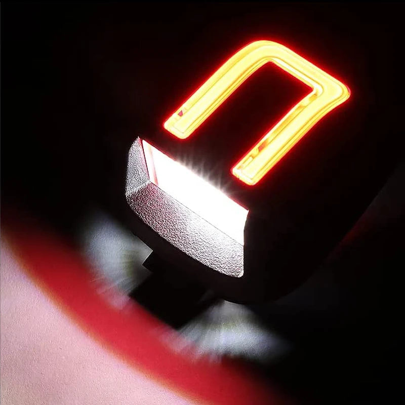 Close-up of an LED license plate light assembly with a bright orange illuminated rectangular housing.