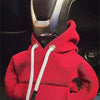 A red cozy knit hoodie is shown with a black cord attached, positioned over a gear shift cover.