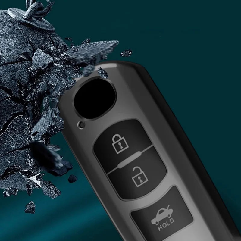 A close-up of a black car key cover with security features, shown next to shattered dark material.