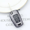 A close-up of a gray universal car key cover resting on a white circular background.