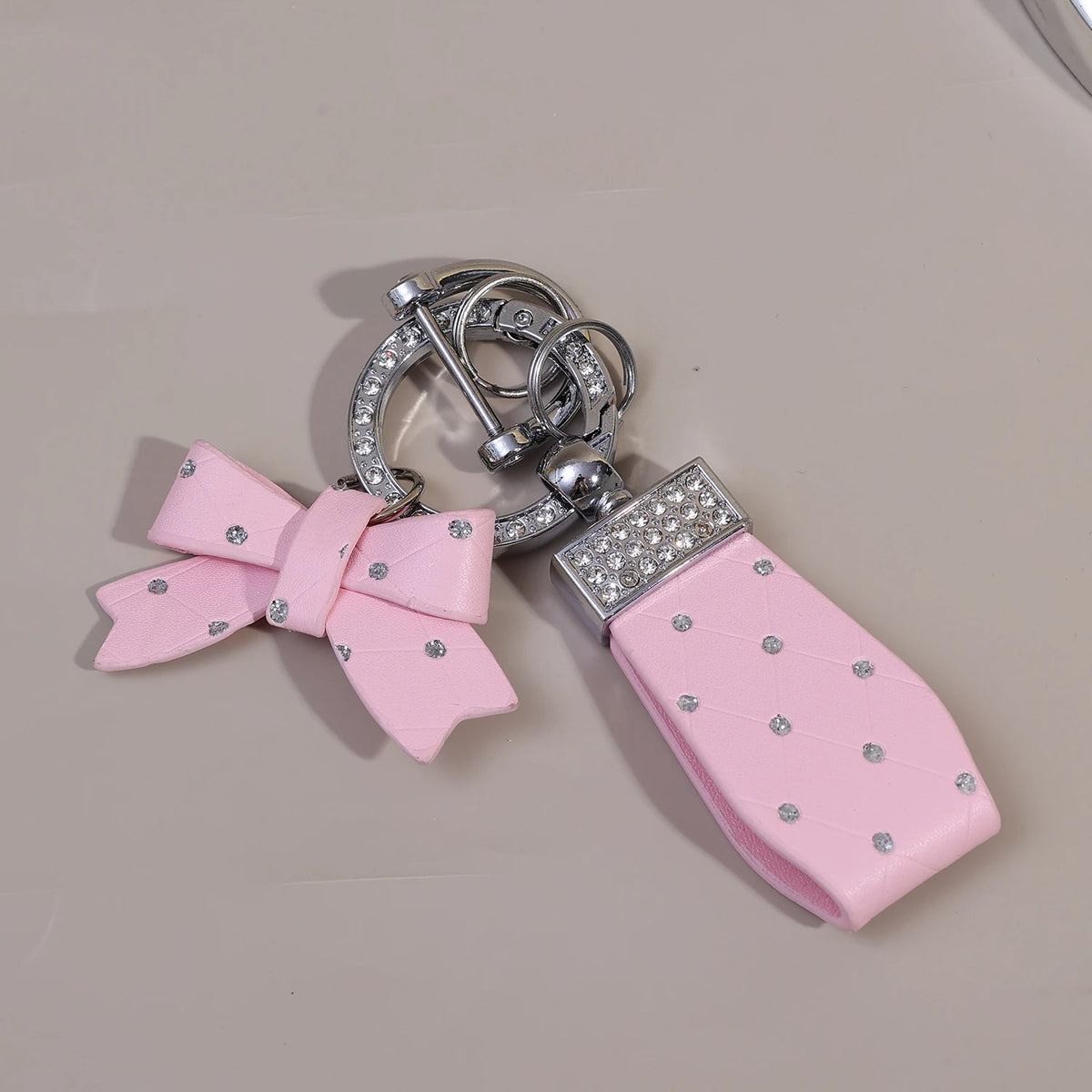 Rosa Luxus-PU-Leder-Bow-Knoten-Anhänger mit silberner Hardware und klaren Strasssteinen.