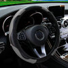 A close-up view of a black steering wheel with a PU carbon fiber cover and controls in a car interior.