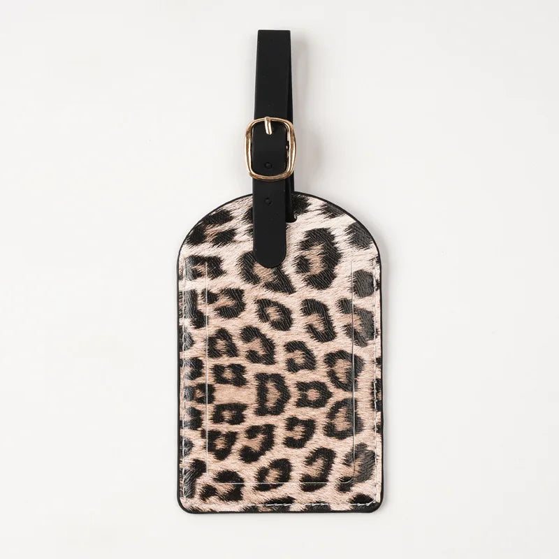 A black leather passport holder with gold hardware featuring a leopard print design.