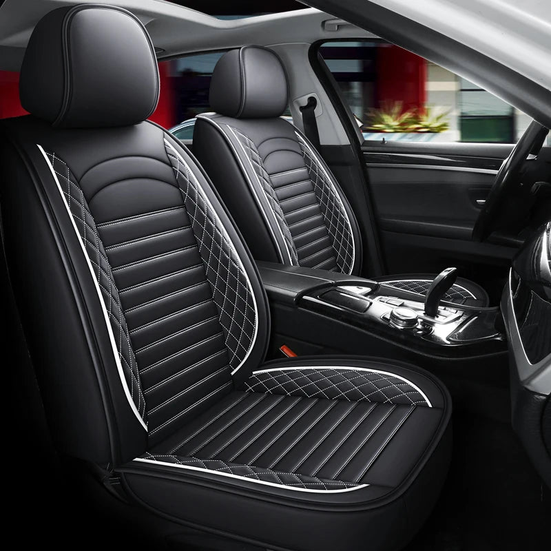 Interior view of a car showing black leather seats with quilted stitching and a mesh seat cushion.