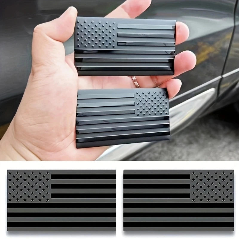 Matte black 3D American flag decals for vehicles shown in a hand