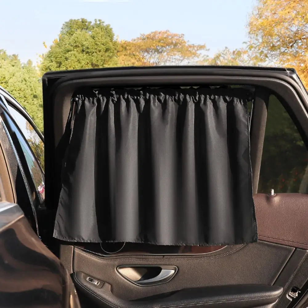 A black suction cup window sunshade is shown inside a car window.