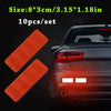 Ten pieces of orange reflective safety strips for vehicle use shown next to a car's taillight.