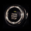 Close-up of a decorative ignition push button cover with an illuminated circular ring and text on a dark background.