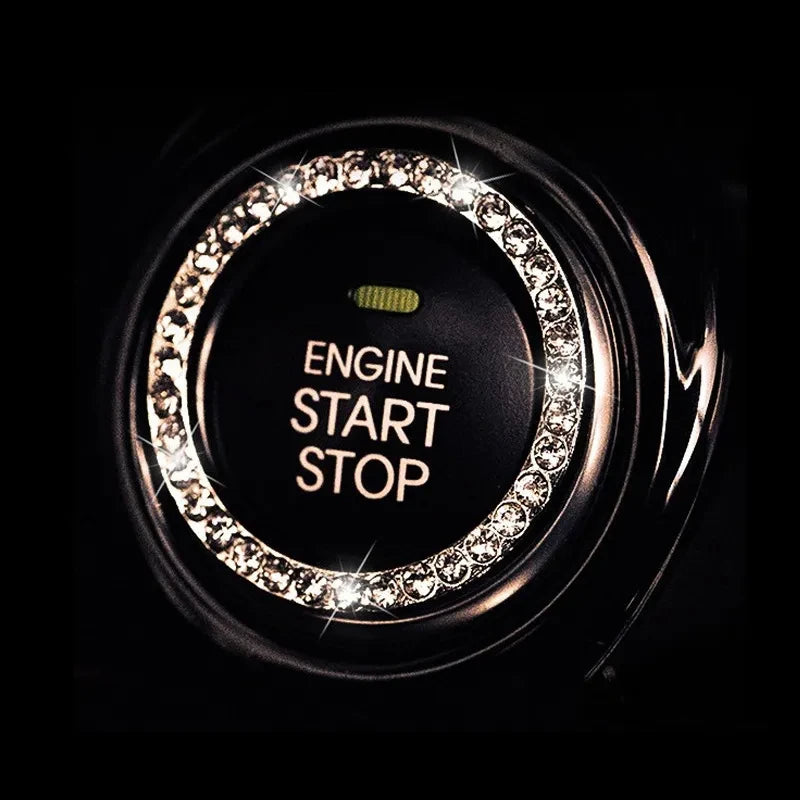Close-up of a decorative ignition push button cover with an illuminated circular ring and text on a dark background.