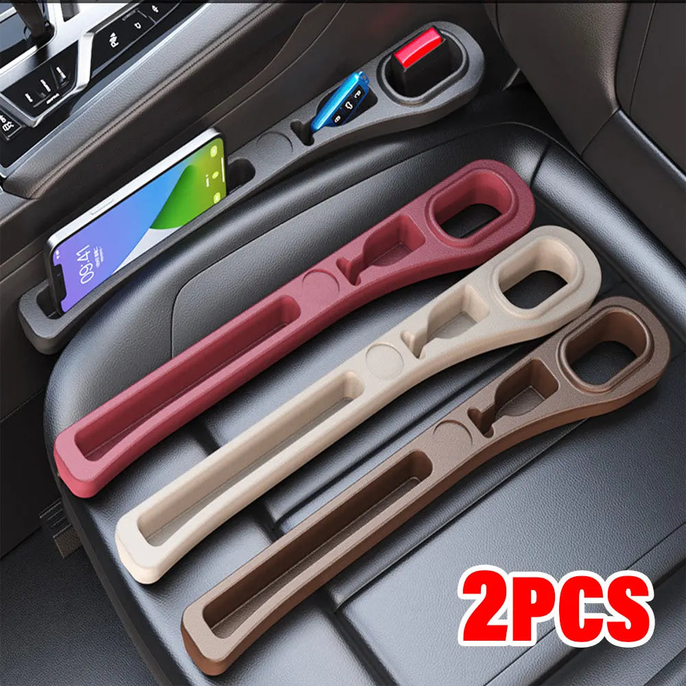 Two silicone car seat gap filler organizers in pink and beige colors placed on a car console.