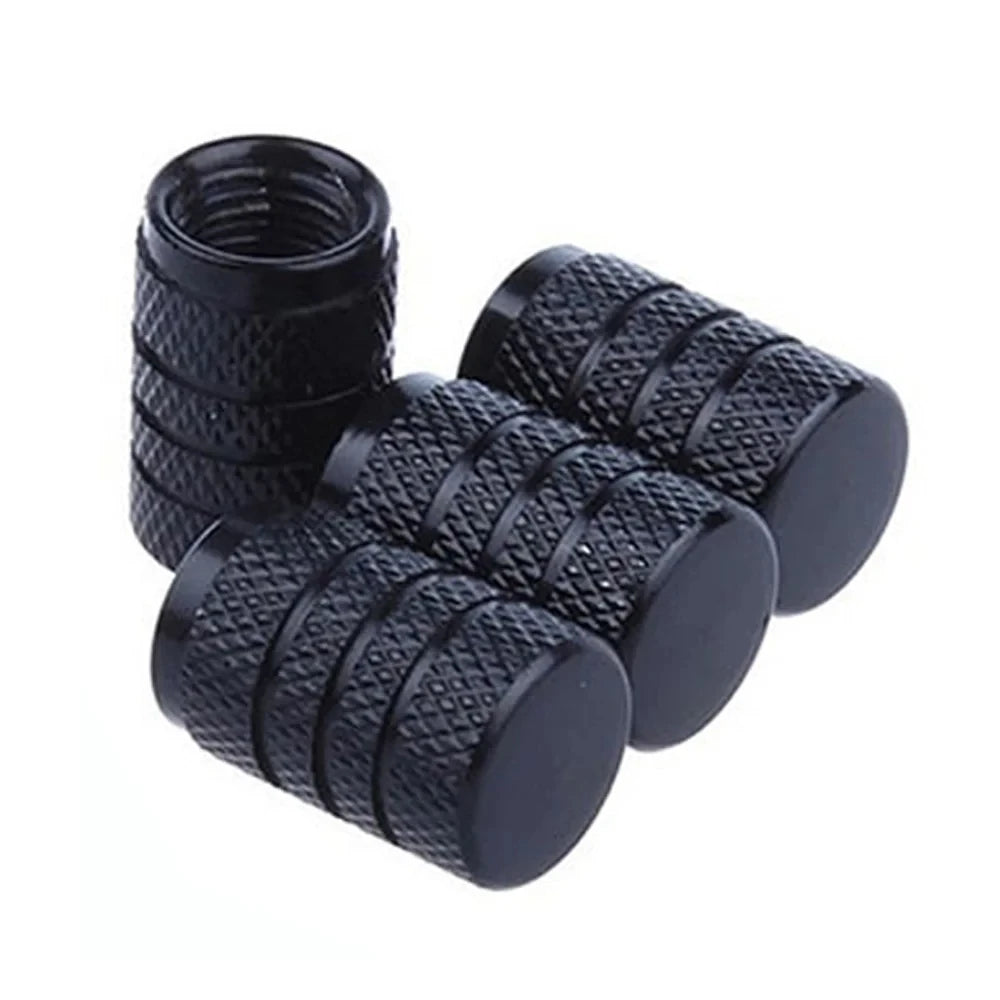 A set of black aluminum tire valve caps with knurled texture.