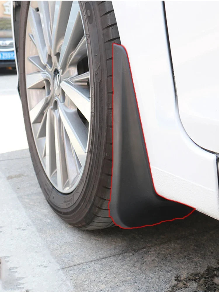 Close-up view of a car wheel with black mud flaps installed on the fender.