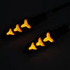 A close-up of a Flowing LED motorcycle turn signal featuring three amber light elements.